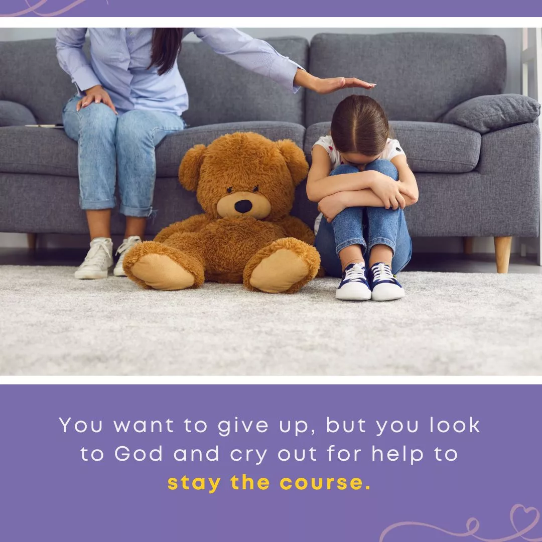 A young girl sits on the floor hugging her knees to her chest beside a large teddy bear, while an adult reaches out a comforting hand toward her. Text overlay reads: "You want to give up, but you look to God and cry out for help to stay the course."