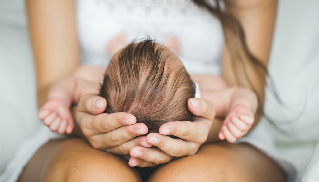 Mother holding adopted baby.