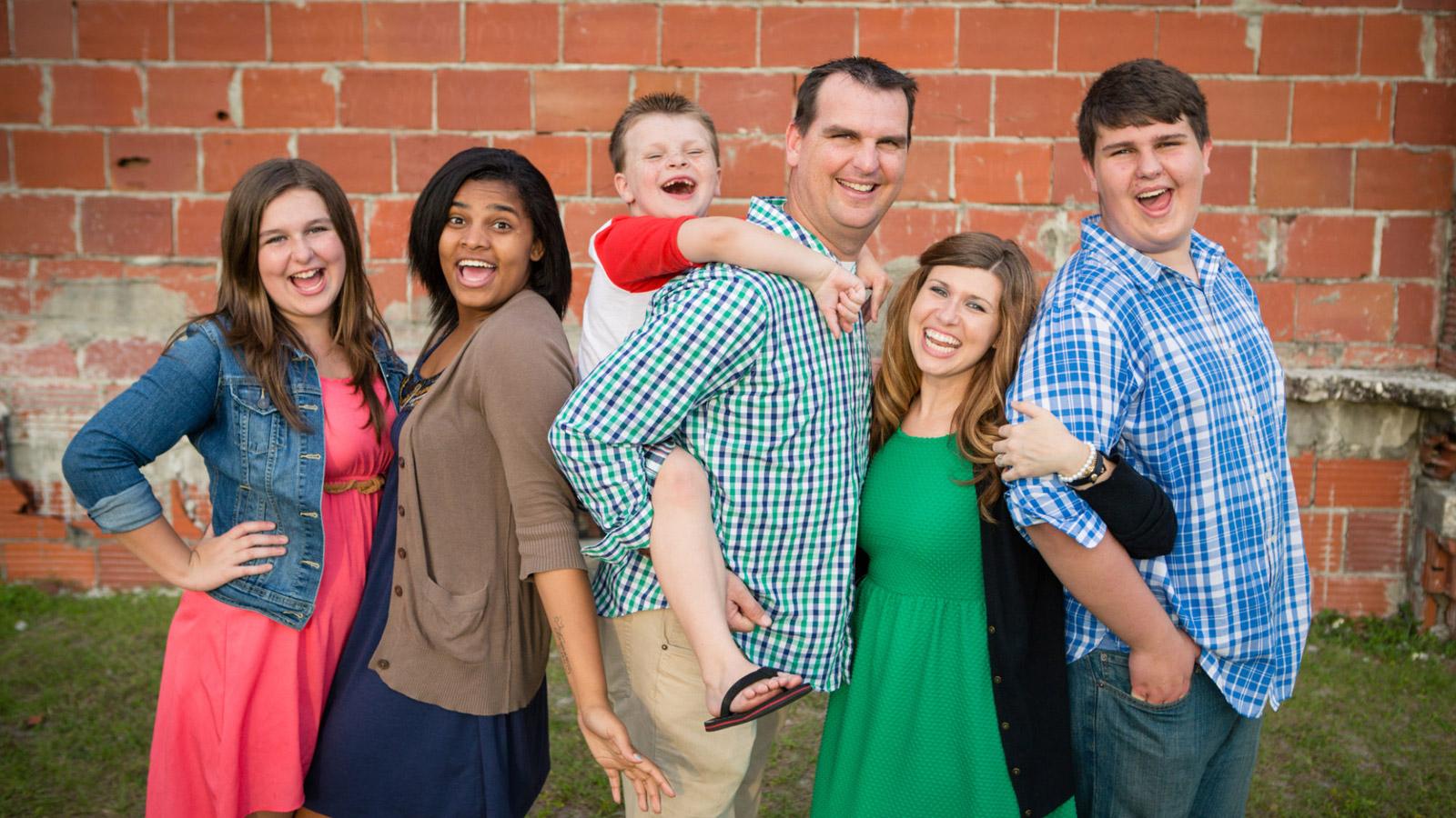 Family laughs and smiles while getting their picture taking.
